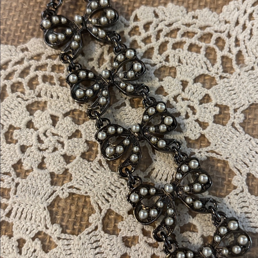 Babylone of Paris Bows Faux Pearls in a Black Laquered Base Metal Setting.